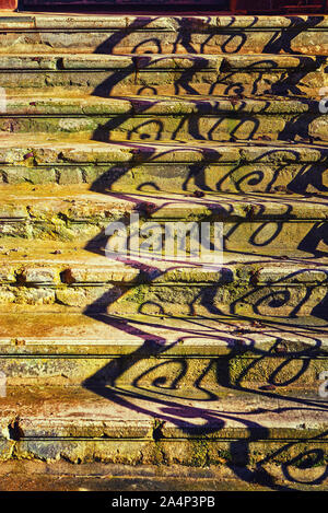 Ancien escalier en pierre avec des ombres sur la rampe. Banque D'Images