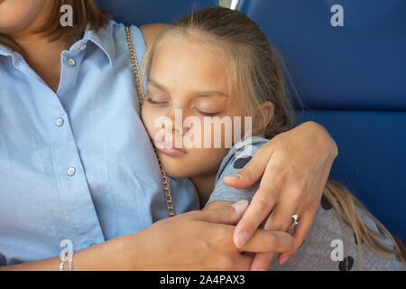 Girl sleeping appuyée sur maman Banque D'Images