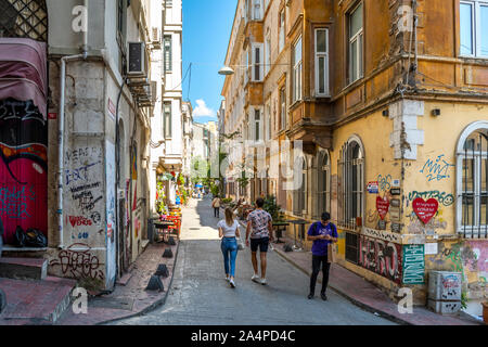 Les touristes y compris un jeune couple à pied jusqu'à une colline près de la tour de Galata dans un quartier coloré de magasins et marchés à Istanbul, Turquie. Banque D'Images