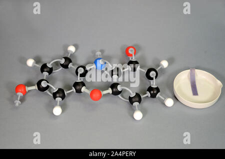 Molécule modèle de mise à l'état en bleu, avec un morceau de papier de tournesol bleu sur une plaque blanche. L'hydrogène est blanc, noir de carbone est, le rouge est l'oxygène, et bl Banque D'Images