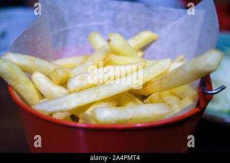 Close-up frites dans un seau en métal sur une table. Banque D'Images