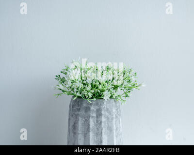 Pot en béton style minimaliste. Close-up fleurs blanches en béton géométrique moderne le semoir sur planche en bois isolé sur fond blanc. Banque D'Images