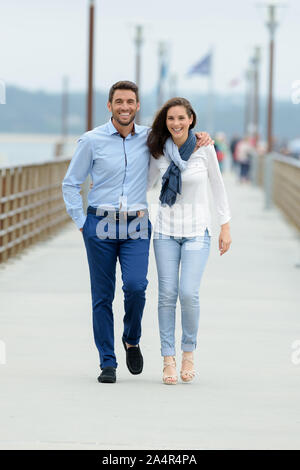 Jeune couple en train de marcher le long de promenade Banque D'Images