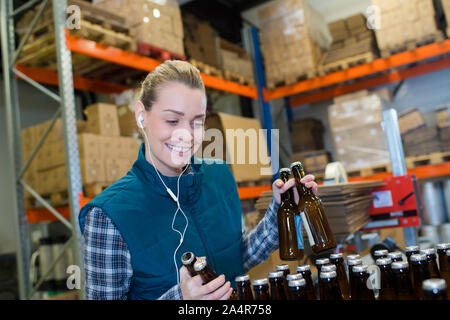 Heureux travailleur féminin sur la ligne de production de l'usine de bière Banque D'Images