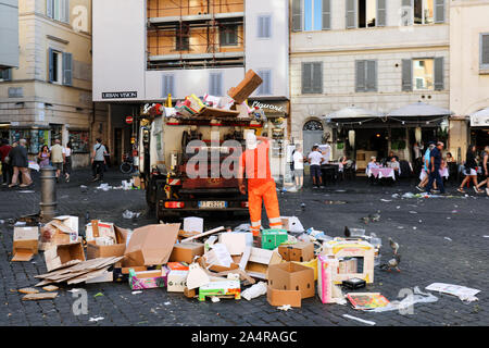 Travailleur de l'assainissement des boîtes de carton vides au petit camion poubelle au Campo de' Fiori place du marché à Rome, Italie Banque D'Images