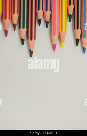 Crayons de couleur Sharp pas alignés horizontalement et placé au-dessus verticalement sur fond blanc Banque D'Images