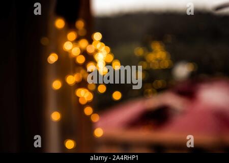 Gouttes de pluie sur la vitre à l'arrière-plan de la ville d'automne. Bokeh chaudes Lumières de flou artistique à l'intérieur de la maison.. Abstrait toile. Gouttes de pluie sur un carreau de fenêtre. Banque D'Images