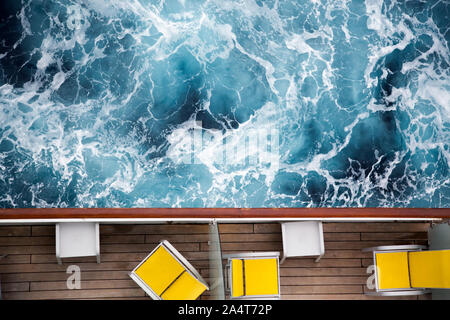 Pont des navires de croisière. Vue de dessus d'un balcon avec des chaises longues jaune et de la mer / océan. Vacances de Croisière vacances concept Banque D'Images