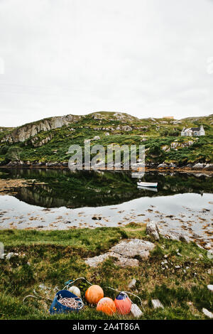 Bateau de pêche en baie et reflet dans le Minch à Détroit (Greosabhagh Grosebay) sur la côte est de l'île de Harris, Hébrides extérieures, en Écosse Banque D'Images