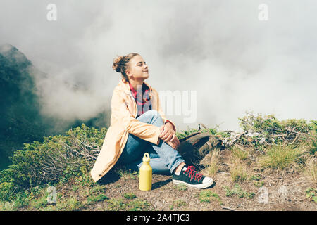 Blanc femme jeune hippie dans les montagnes contre l'arrière-plan de nuages Banque D'Images