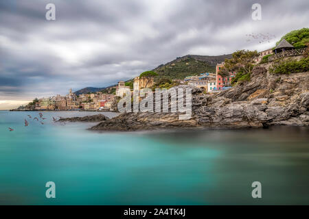 Ville côtière de Bogliasco, Italie. Vue pittoresque du littoral rocheux en premier plan et des maisons d'un village, capturés à l'aide d'une exposition longue, wit Banque D'Images