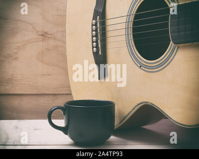 Le café et la guitare sur table en bois. (Vintage) Banque D'Images