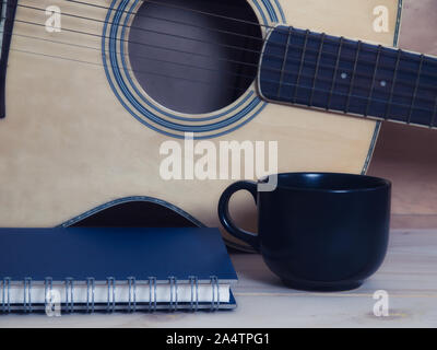 Café , réservez et guitare sur table en bois. Banque D'Images