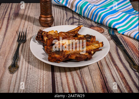 Côtes d'agneau mariné aux épices grillés dans un plat sur la table Banque D'Images