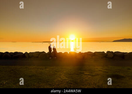 Couple taking pictures of the sunset, Saebraut street, Reykjavik, Islande Banque D'Images