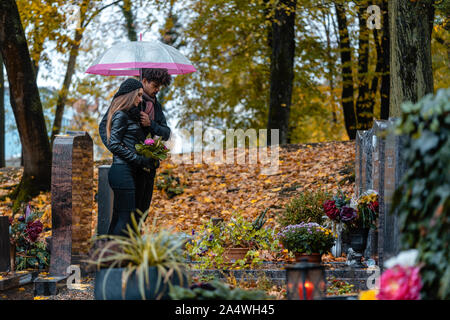 L'homme et la femme sur un cimetière avec des fleurs Banque D'Images