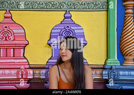 , Selangor, Malaisie Gombak 08.14.2019 : une belle fille brune thaï est observer les étoiles en face d'un mur coloré à Batu Caves Banque D'Images