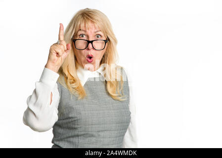 Surpris mature woman with glasses points doigt vers le haut, isolé sur fond blanc. Banque D'Images
