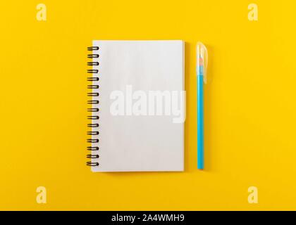 Ouvrez le bloc-notes à spirale sur fond jaune , carnet et un stylo se coucher sur papier texturé, télévision lay concept Banque D'Images