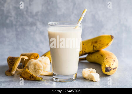 Smoothie banane de bananes biologiques. Il y a un verre rempli de smoothie banane dans le centre, et les bananes et les pelures de banane autour du verre. Wifi Banque D'Images