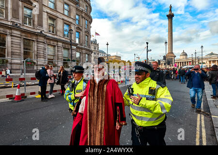 Londres, R.-U. - Oct 16, 2019 : Woodbridge maire et députée du Parti Vert, Eamonn O'Nolan, vêtus de robes, civique est emmené par la police après avoir été arrêté pour bloquer une route à Trafalgar Square. Banque D'Images