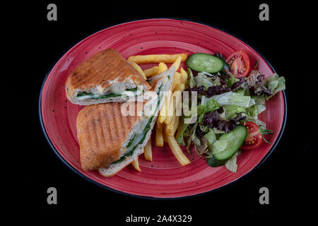 Et grillé avec fromage fumé toast pressé, tomate et laitue servis sur fond noir. Banque D'Images