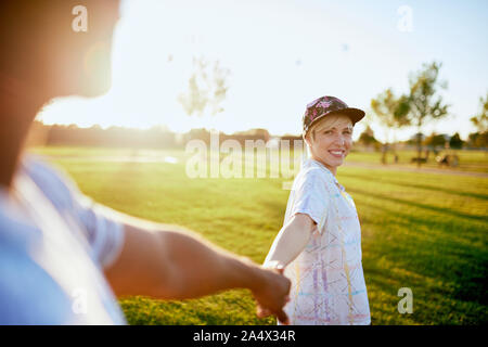 Mixed Race couple de milliers dans un champ d'herbe et de marche hol Banque D'Images