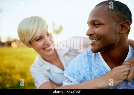 Mixed Race couple de milliers dans un champ d'herbe pour une adoption Banque D'Images