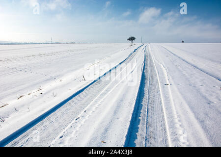 Les traces de pneus sur la route couverte de neige, hiver, sur l'est de la Pologne Banque D'Images