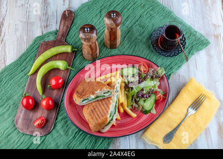 Et grillé avec fromage fumé toast pressé, tomate et laitue servi sur fond de bois. Banque D'Images