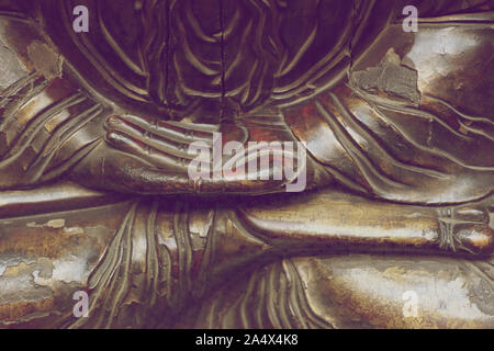 Fragment d'une statue en bois d'une divinité orientale dans une pose de méditation Banque D'Images