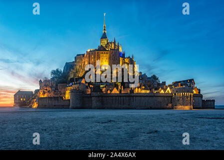 Coucher du soleil sur le Mont Saint Michel avec un bel éclairage d'un lampadaire. Banque D'Images