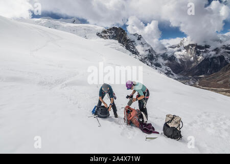 Deux femmes alpinistes prendre une pause d'engrenage sur le Glacier Peak Mera Banque D'Images