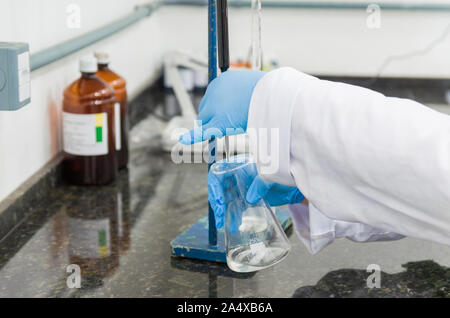 Titrage des mains femme test sur le contrôle de la qualité des produits chimiques. Banque D'Images