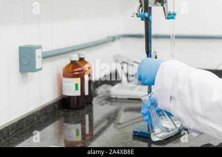 Titrage des mains femme test sur le contrôle de la qualité des produits chimiques. Banque D'Images