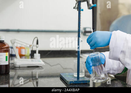 Titrage des mains femme test sur le contrôle de la qualité des produits chimiques. Banque D'Images