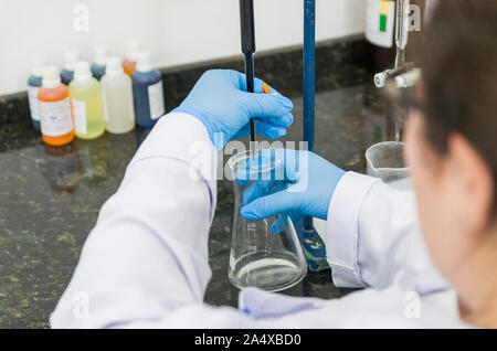 Titrage des mains femme test sur le contrôle de la qualité des produits chimiques. Banque D'Images