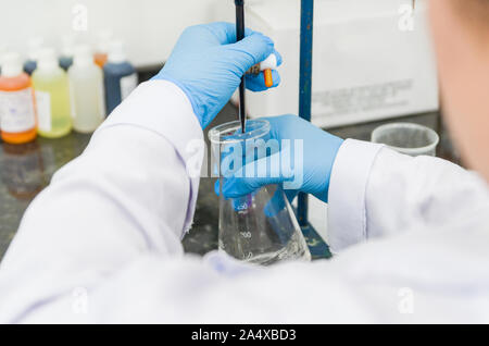 Titrage des mains femme test sur le contrôle de la qualité des produits chimiques. Banque D'Images