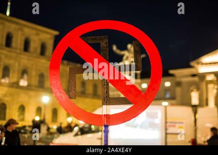 Munich, Bavière, Allemagne. 16 Oct, 2019. Un manifestant contre Michael Stuerzenberger est titulaire d'une croix gammée c'est barré. Collègues de Stuerzenberger ont été associées à des néonazis et de l'antisémitisme. Malgré une récente condamnation pour incitation des masses, islamophobe Michael Stuerzenberger ont organisé une manifestation sous la bannière en Buergerbewegung Pax Europa Munich's Max Joseph Platz. Au moins une plainte pénale contre Chris K., Stuerzenberger's assistant a été déposée en raison de l'insulte à un manifestant. Credit : Sachelle Babbar/ZUMA/Alamy Fil Live News Banque D'Images