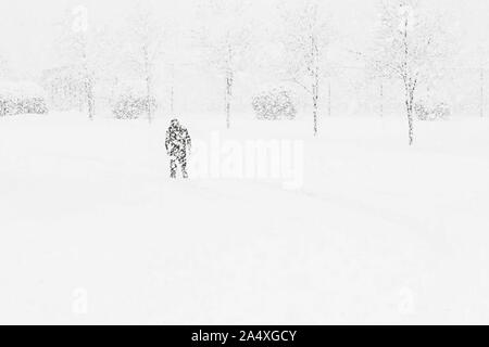 Un homme ventures dans une tempête de neige aveuglante sur une journée à la maison du travail. Banque D'Images