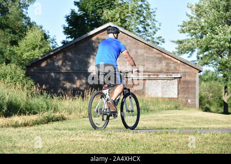 Athlète masculin de l'exercice cycliste retraité portant casque cycliste Banque D'Images