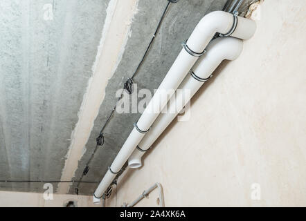 Les tuyaux de ventilation en plastique sont fixés sur le plafond en béton. Banque D'Images