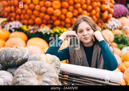 Une adolescente aux cheveux roux avec des taches de rousseur sur le visage est assis près d'un panier pumpkins Banque D'Images