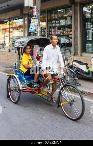 Mae Sot, Thaïlande - 3 Février 2019 : Femme et enfant voyageant dans un cyclo. Cette forme de transport est en train de mourir. Banque D'Images