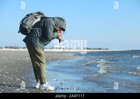 Old Lyme, CT / USA - 4 mars 2019 Photographe : par temps froid gear prend des photos sur la plage à Hammonasset State Park Banque D'Images