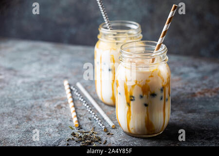 Light Brown bubble tea crème de lait et de tapioca noir dans un bocal en verre sur fond gris Banque D'Images