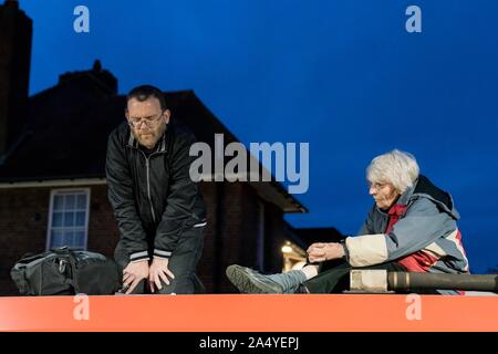 Londres, Royaume-Uni. 17 Oct, 2019. Les membres du Climate Action Chrétienne Père Martin Newell (52), prêtre de Birmingham et Rev. Sue Parfitt (77) de Bristol, grimper sur le toit d'un train à Shadwell DLR station au cours de l'extinction des manifestations de rébellion dans le centre de Londres, au Royaume-Uni. Crédit : Vladimir Morozov/Alamy Live News Banque D'Images