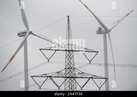 16 octobre 2019, le Brandebourg, Bernau/Ot Birkholz : Windmills tour devant un ciel gris pluvieux derrière une colonne d'alimentation. Photo : Soeren Stache/dpa-Zentralbild/ZB Banque D'Images