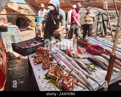 Pêcheur marocain organisation de fruits de mer frais sur la table pour la vente sur les marchés traditionnels de poissons à Essaouira, Maroc Banque D'Images