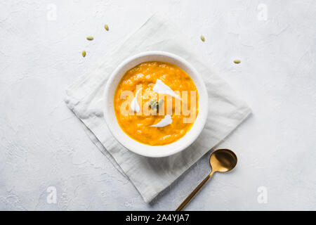 Soupe aux carottes et à la citrouille d'automne avec de la crème sur fond noir en gris. Vue de dessus et de l'espace pour le texte. Banque D'Images